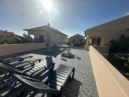 a group of lounge chairs sitting on a patio at Maresia's House in Madalena do Mar