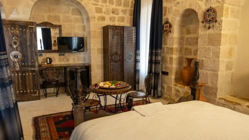 a bedroom with a bed and a table in a room at Vezir Konağı Hotel in Mardin