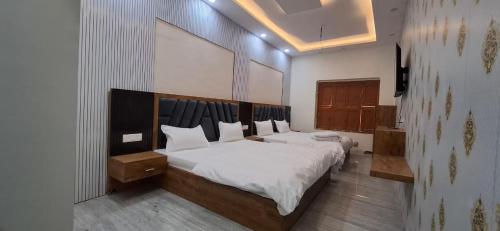 a bedroom with a large bed with white sheets at Keshav Homestay in Varanasi