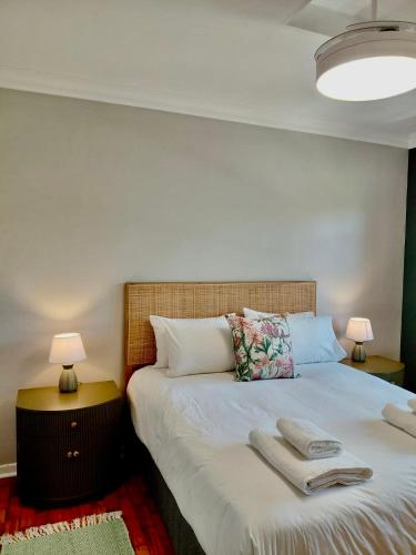 a bedroom with a large bed with towels on it at The Botanic Venus in Paarl
