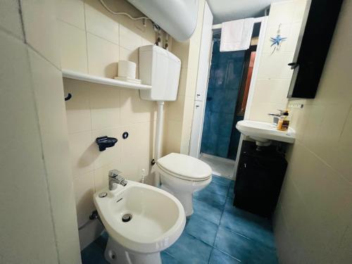 a small bathroom with a toilet and a sink at The Blue Nest Suite - Sanremo in Sanremo
