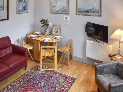 a living room with a couch and a table at The Coach House - Uk50884 in North Walsham