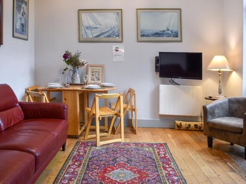 a living room with a couch and a table at The Coach House - Uk50884 in North Walsham