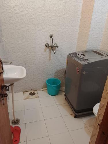 a bathroom with a sink and a washing machine at Esadan in Agra