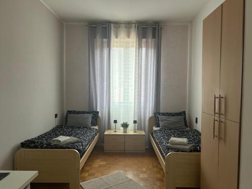 two beds in a room with a window at Lake Garda in Gavardo
