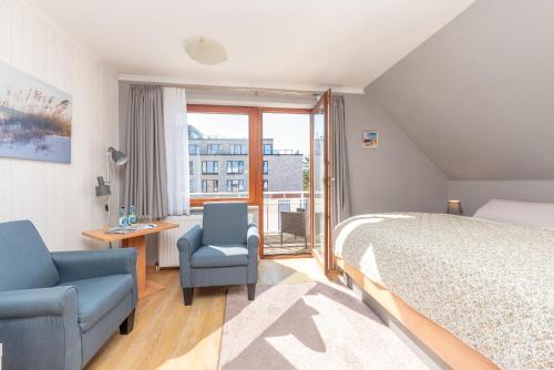 a bedroom with a bed and a chair and a window at Hotel Villa Sonneck-Adults Only in Böhl