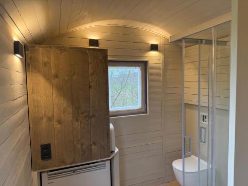 a small bathroom with a toilet and a window at BelleLiv in Nijlen