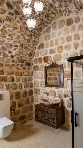 a stone bathroom with a sink and a mirror at Vezir Konağı Hotel in Mardin