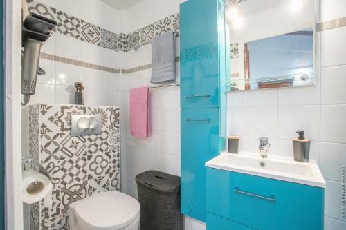 a bathroom with a blue cabinet and a sink at Alpinia-Martinique, à 5 minutes de la plage in Sainte-Anne