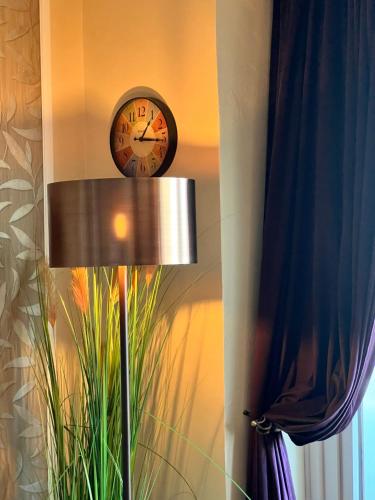 a clock hanging on a wall next to a lamp at Premium Apartment-OstseePur-inklusive Parkplatz-Wlan-Strand-und Citynähe in Timmendorfer Strand