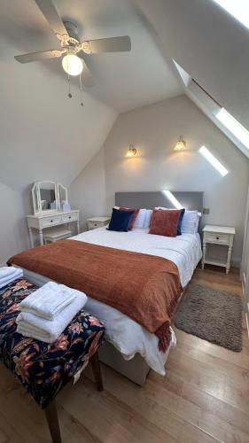 a bedroom with a large bed and a ceiling fan at The Coach House WPH, Epping in Epping