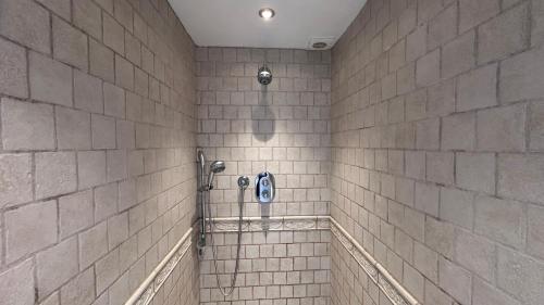 a bathroom with a shower with white tiled walls at The Coach House WPH, Epping in Epping
