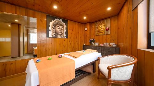 a room with a bed and a chair in it at Yashshree Jai Hotel & Banquet in Darjeeling