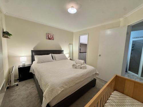 a bedroom with a bed with two stuffed animals on it at Private Farmhouse & Paddock Available in Werribee South