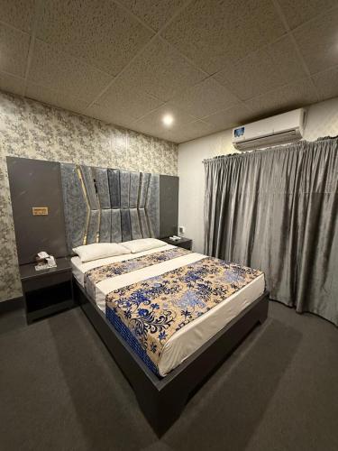 a bedroom with a large bed in a room at Glorious Guest House & Hotel in Multan
