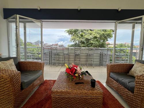 a living room with two couches and a table with flowers at Suite de hotel dentro centro comercial in Cartago