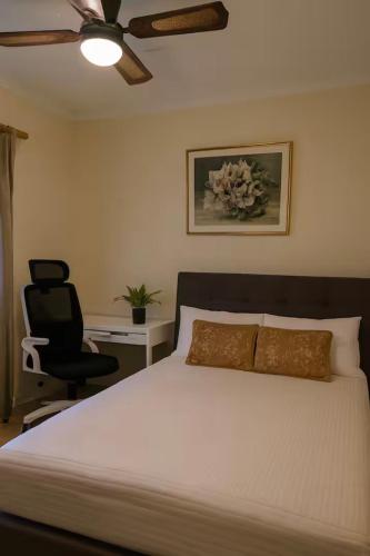 a bedroom with a bed and a desk and a chair at The Haven House in Singleton