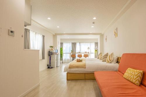 a bedroom with a bed and a couch at night-night 東京ドーム便利 江戸川橋駅近 池袋銀座直通 商店街徒歩圏内 in Tokyo
