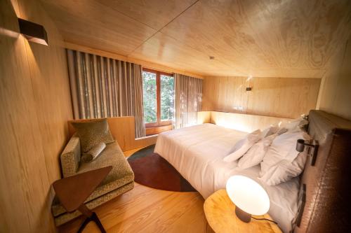 a bedroom with a bed and a table and a chair at Torre de Gomariz Wine & Spa Hotel in Braga