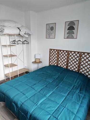 a bedroom with a blue comforter on a bed at Appart 1 bray dunes Minouche in Bray-Dunes