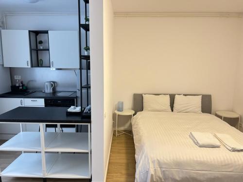a small bedroom with a bed and a desk at Studio Pompeiu in Bucharest