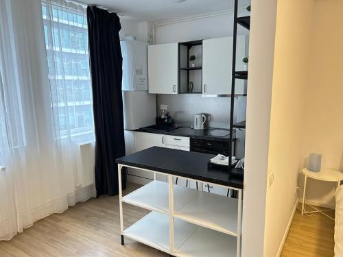 a kitchen with white cabinets and a black counter top at Studio Pompeiu in Bucharest