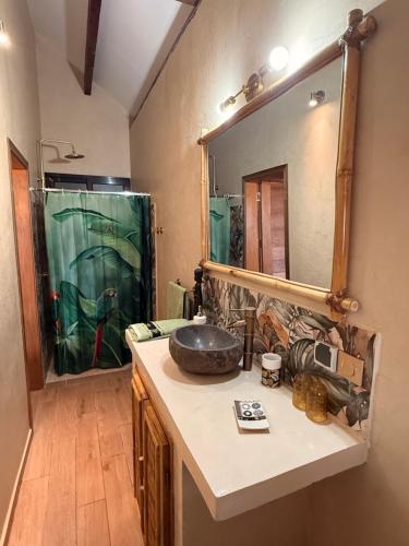 a bathroom with a sink and a large mirror at Téranga paradis in Somone