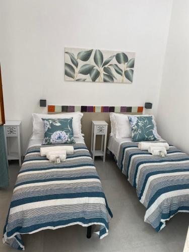 two beds sitting next to each other in a room at B&B RoseMary in La Maddalena