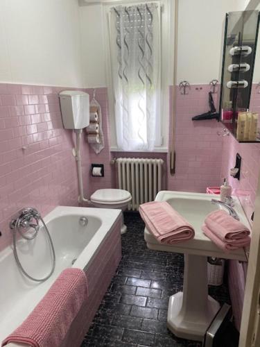a pink bathroom with a tub and a sink and a toilet at La Terasa del Cichino in Roe