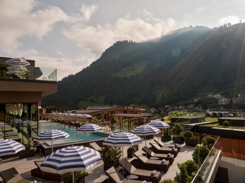 a view of a resort with umbrellas and a pool at DAS EDELWEISS - Salzburg Mountain Resort in Grossarl
