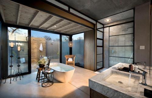 a large bathroom with a tub and a sink at Lion Sands Ivory Lodge in Sabi Sand Game Reserve
