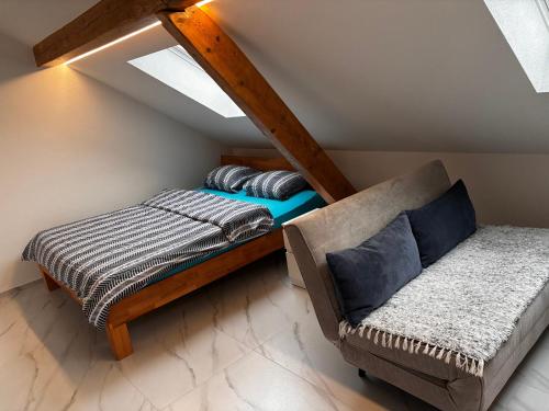a attic room with a bed and a couch at Studio Alma in Bôle