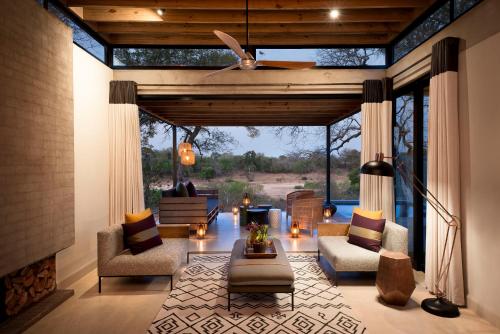 a living room with a couch and chairs and a fireplace at Lion Sands Ivory Lodge in Sabi Sand Game Reserve