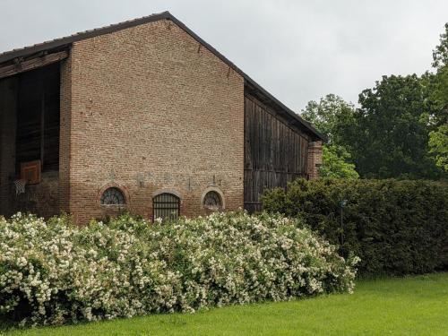 an old brick building with some flowers in front of it at Podere Misericordia in Ferrara