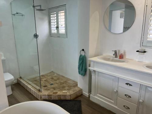 a bathroom with a shower and a toilet and a sink at The Windsock in Ballito