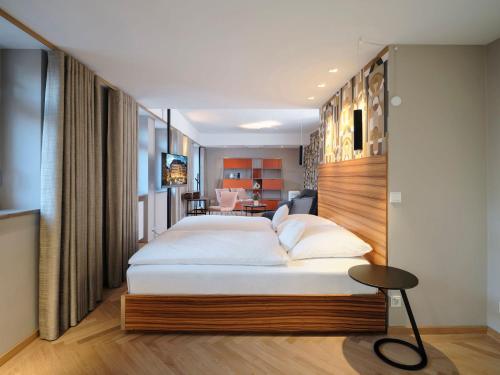 a bedroom with a large bed and a desk at Hotel VICTORIA Nürnberg in Nuremberg
