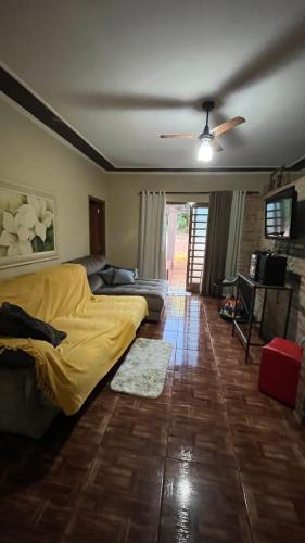 a living room with a bed and a couch at A área Orioli in Jardinópolis