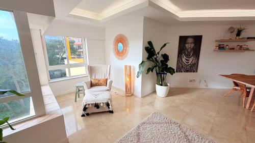 a living room with a chair and a table at Oceanfront 2 bedrooms apartment with swimming pool & garage in Cascais