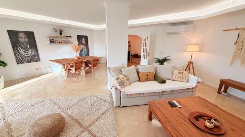 a living room with a couch and a table at Oceanfront 2 bedrooms apartment with swimming pool & garage in Cascais