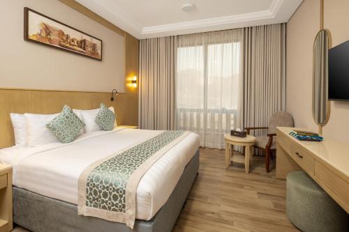 a hotel room with a bed and a desk at فندق عفراء in Mecca