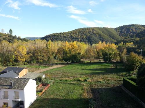 a large yard with trees and mountains in the background at Hotel Rural Pescadores in Sobrado