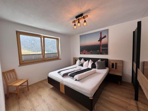 a bedroom with a bed with a cross picture on the wall at Ferienwohnungen Moser in Steinberg am Rofan