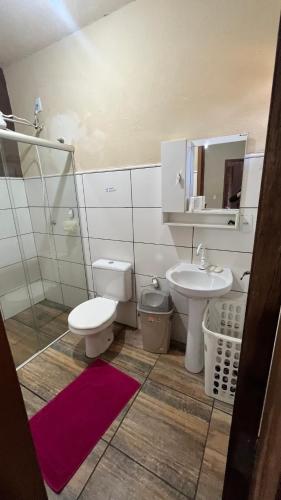 a bathroom with a sink and a toilet and a mirror at A área Orioli in Jardinópolis