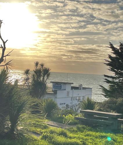 a building on the beach with the ocean in the background at Little Yacht Inn in Penzance