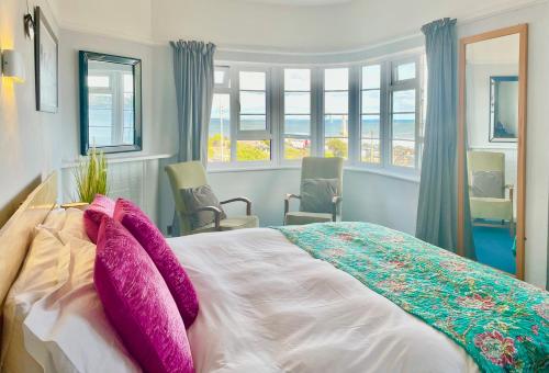 a bedroom with a large bed with purple pillows at Little Yacht Inn in Penzance