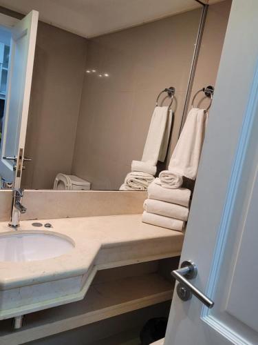 a bathroom with a sink and a mirror and towels at Green Park Solanas Monoambiente Punta del Este in Punta del Este