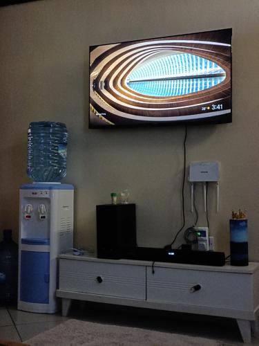 a tv hanging on a wall above a table at Mwangaza studios in Mombasa