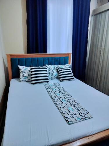 a bedroom with a bed with blue curtains at Mwangaza studios in Mombasa