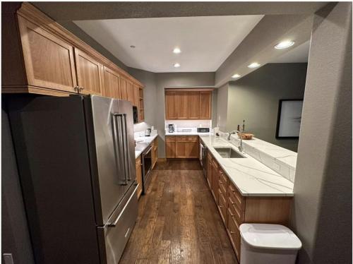 a kitchen with wooden cabinets and a black refrigerator at Lodge at Brookside, A Vail Resorts Property in Avon