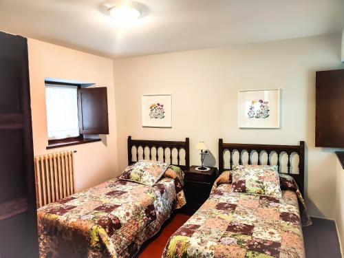 ein Schlafzimmer mit zwei Betten und einem Fenster in der Unterkunft Casa Azón in Oliván